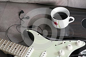 Coffee mug and a stratocaster guitar and earphones