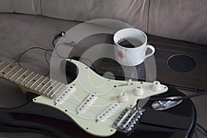 Coffee mug and a stratocaster guitar and earphones photo