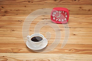 Coffee Mug on Wooden Table with red clock