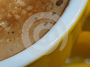 Coffee in mug yellow background