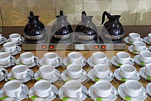 Coffee mugs and hot tea ready to drink on the electric stove in the hotel`s seminar and meeting rooms