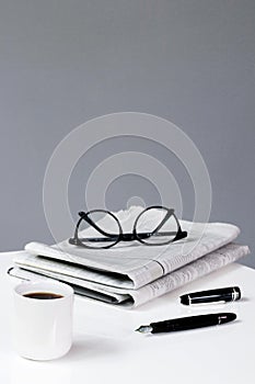 coffee newspaper break business background with pen and glasses financial