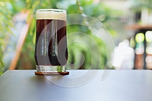 Coffee Nitro Cold Brew in glass on table outdoor cafe