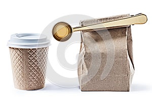 Coffee papercup and paperbag with big golden scoop isolated photo