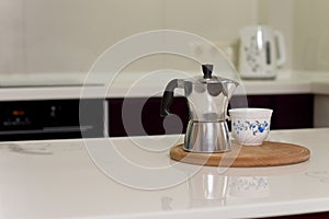 Coffee percolator and cup on a kitchen counter photo