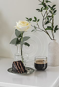 Coffee and a piece of chocolate cake on the table in a bright room