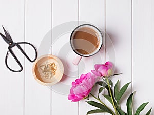 Coffee and pink peonies on the white tabel