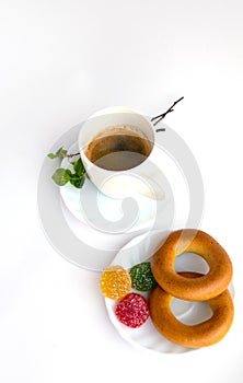 Coffee, plate with bagels, marmalade, sprig of birch with green leaves