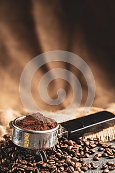 Coffee portafilter with coffee beans. Stone background