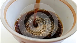 Coffee is poured into the cup slow motion