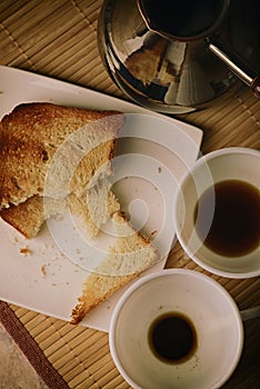 Coffee is poured into white cups. Toasted bread. Breakfast on the table