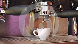 Coffee pouring into the cup in the professional coffee machine