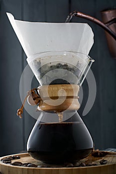 Coffee pouring into a glass coffee maker. Pour Over Coffee in a decanter, a carafe for coffee on a white coffee set background,