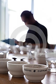 Coffee professional q grader testing and inspecting the quality of arabica coffee beans. coffee grounds in a cup on the table