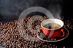 Coffee in red cup and coffee beans are the background.