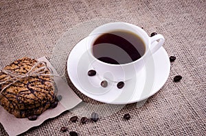 Coffee with seeds and cookies on the background of burlap