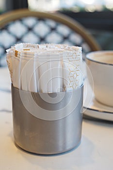 Coffee setup with sugar packets and cup on a table