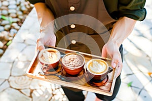 Coffee shop. Crop shot of a waiter holding a wooden tray with cappuccino coffee