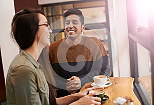 Coffee shop, happy and couple laugh with drink in conversation, talking and chatting for bonding. Love, morning and man