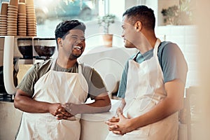 Coffee shop, happy and male barista talking to his colleague before work at a restaurant or cafe. Happiness, smile and