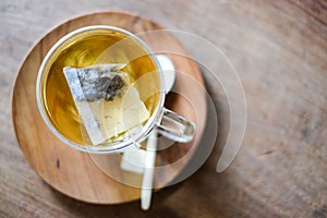 In coffee shop, the hot lavender tea in glass serve with wooden spoon & saucer on the table for relax and slow life concept