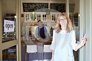 Coffee shop owner businesswoman waiting for her guest while young barista standing in the background