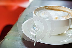 Coffee with spice and artistic foam in a white cup