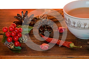 Coffee, spices and pine cones on a wooden background. Christmas concept. A cup of hot coffee with milk, cinnamon and chili on a wo