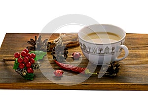 Coffee, spices and pine cones on a wooden background. Christmas concept. A cup of hot coffee with milk, cinnamon and chili on a wo