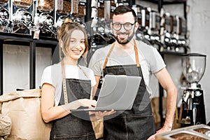 Coffee store owners working with laptop indoors