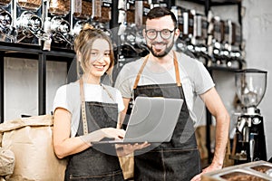 Coffee store owners working with laptop indoors photo
