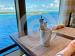 Coffee on a table aboard a cruise ship overlooking the beautiful turquoise waters of the Bahamas