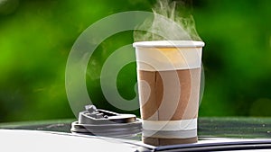 coffee takeaway in a paper cup on top of the car roof green tree background at sunrise in the morning,  selective focus, soft