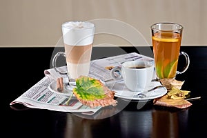 Coffee, tea, latte with dry leaves and newspapers