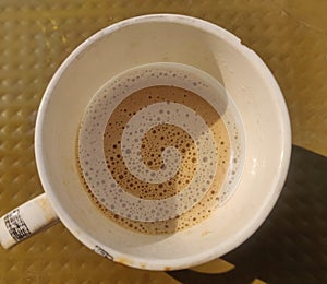 Coffee or tea with milk in white cup isolated over brown background.Malaysian favourite drink called "Teh Tarik".