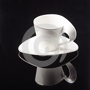 Coffee tea porcelain clay cup with saucer on the black mirror background. Copy space