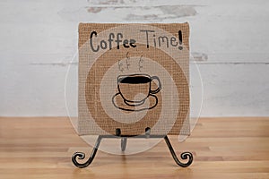 Coffee time sign with a hand drawn coffee mug on square burlap canvas