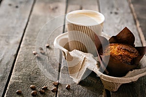 Coffee to go with muffin on wood background photo