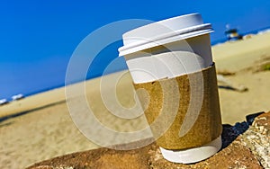 Coffee to go mug on the beach sand sea waves