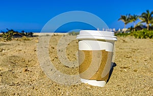 Coffee to go mug on the beach sand sea waves