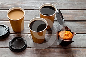 Coffee to take away, muffin on wooden background. Translation of the Russian text on the lid is Caution: contents hot.