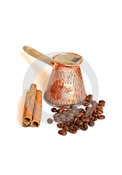 Coffee in vintage copper turkish coffee pot (cezve or ibrik) , coffee beans and cinnamon sticks on white photo