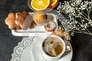 Coffee in white cup and cakes,a saucer with orange slices