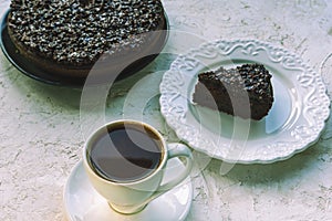 Coffee in white cup and chocolate cake on white table
