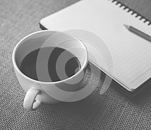 Coffee in white cup with Journal book and pencil