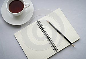 Coffee in white cup with Journal book and pencil