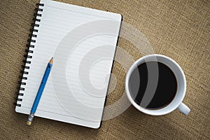 Coffee in white cup with Journal book and pencil