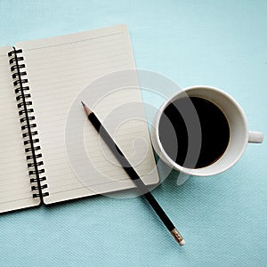 Coffee in white cup with Journal book and pencil