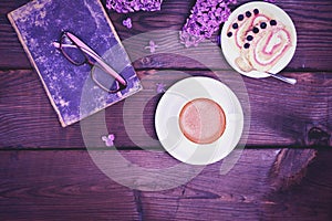 Coffee in a white cup with a saucer and a biscuit cake on a wood