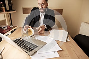 Coffee in white cup spilling on the table in the morning working day at office table